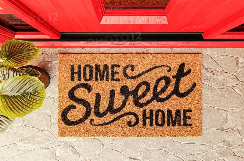 Home sweet home doormat on the porch at the red front door