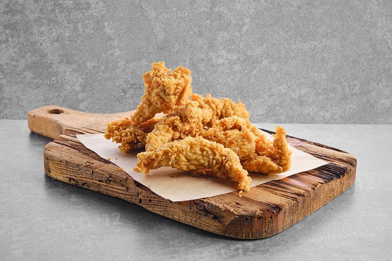 Deep fried chicken nuggets in breading on parchment paper