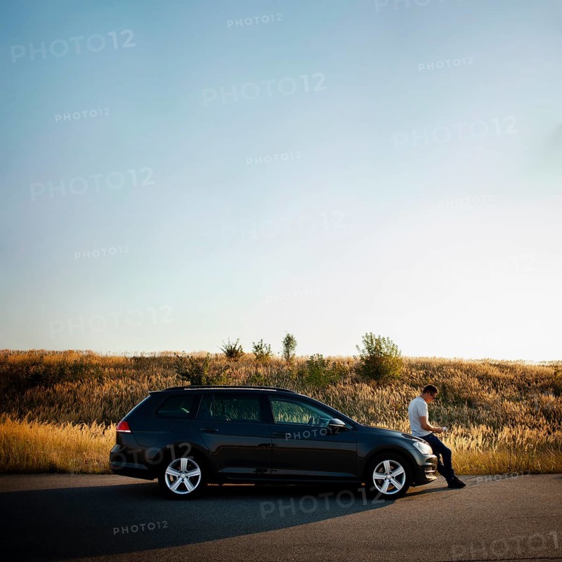Man sitting car hood