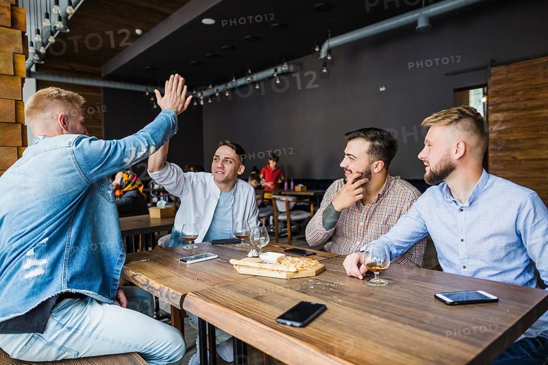 Young man giving high five his friends restaurant