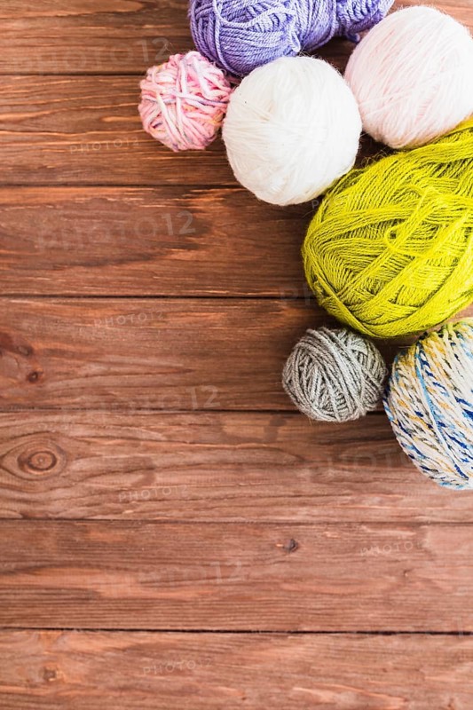 Multi colored ball yarns wooden background