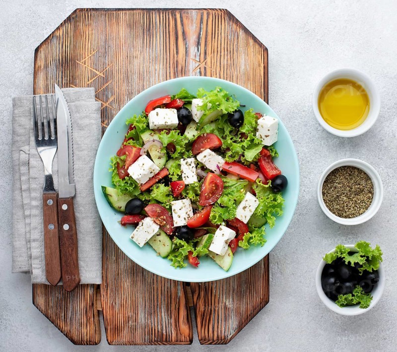 Top view salad with feta cheese cutting board with olives