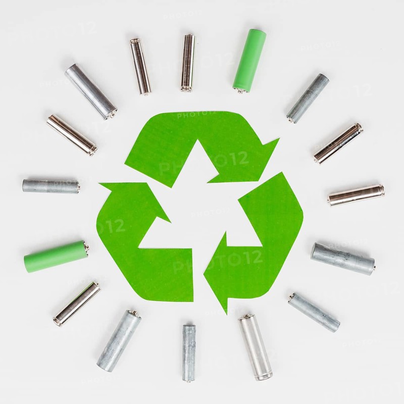 Recycle logo surrounded by trash batteries