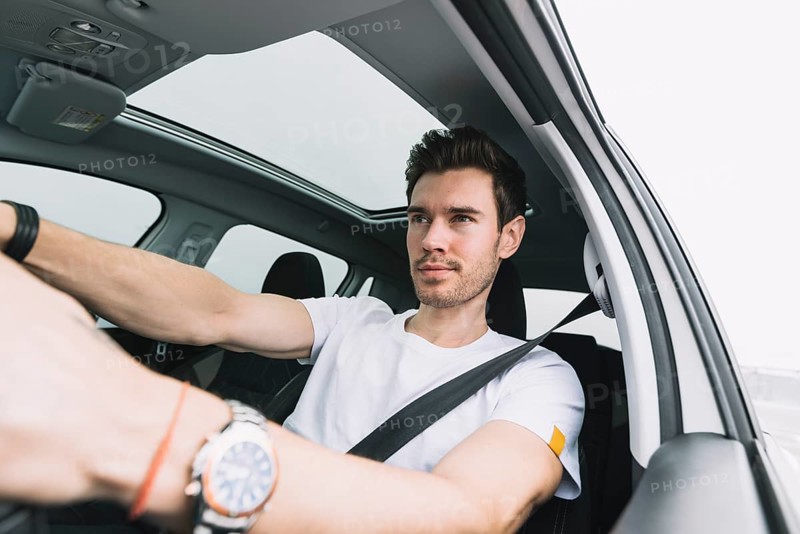 Close up young man driving car