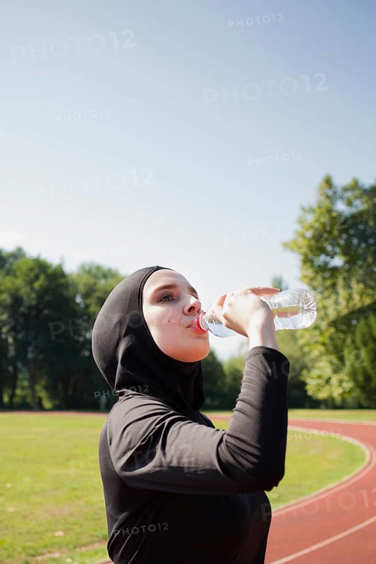Woman drinking water from plastic bottle