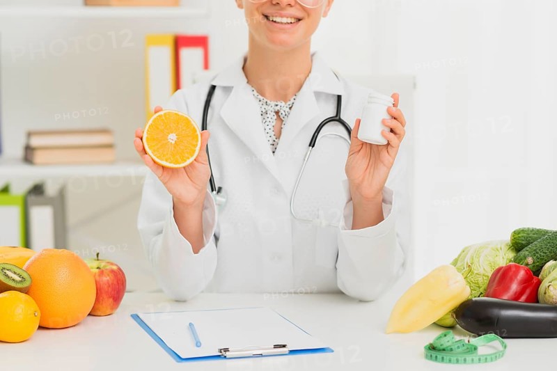 Close up doctor holding up half orange