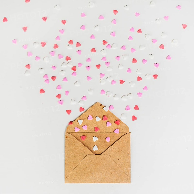 Envelope with small paper hearts white table