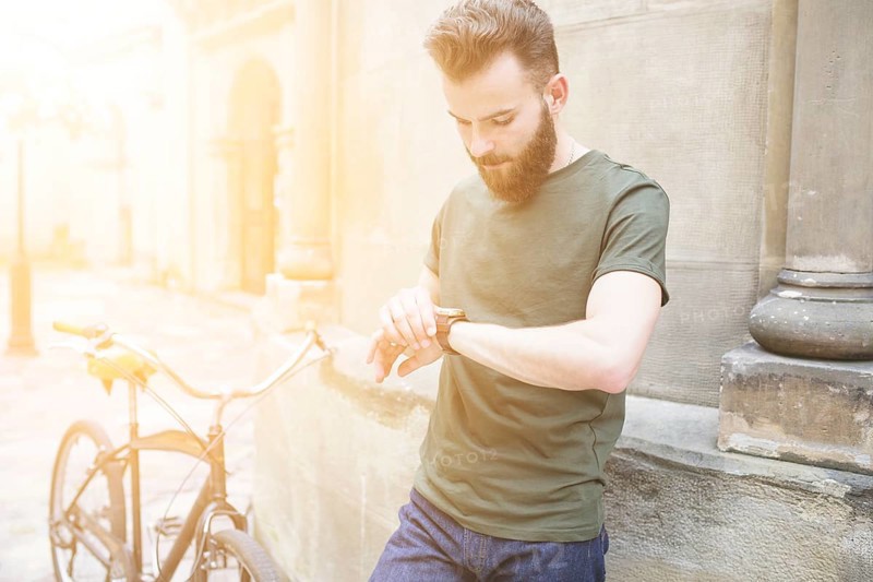 Male cyclist looking time wrist watch