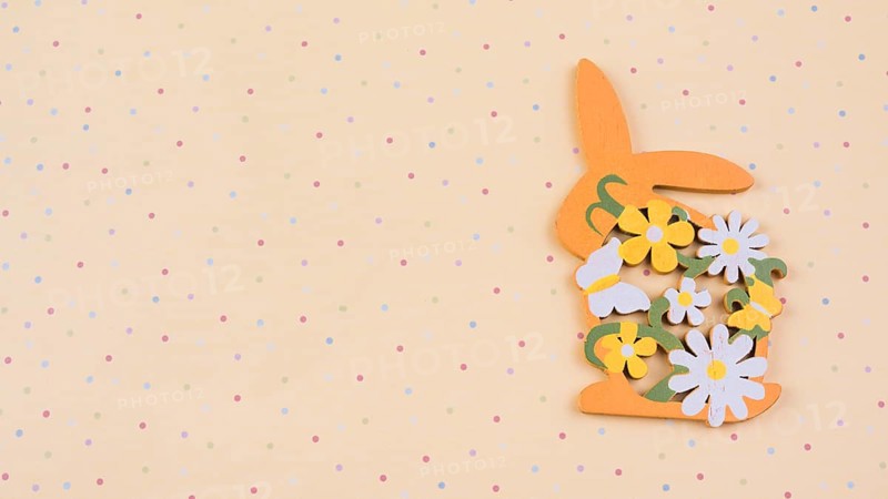 Wooden rabbit with flowers beige table