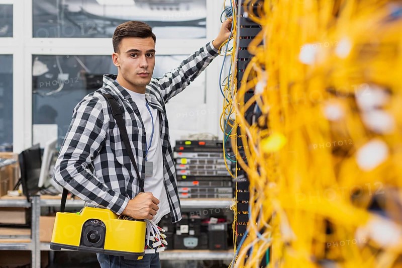 Young network engineer with box working ethernet switches