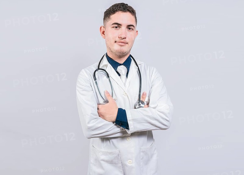 Portrait of handsome doctor with arms crossed isolated. Latin doctor with crossed arms on white background