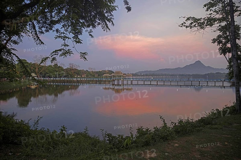 Wooden bridge over Kan Thar Yar Lake at sunset