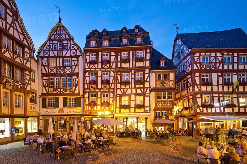 Gabled half-timbered houses on the busy medieval market square in the evening