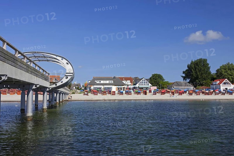 Sea bridge and roofed wicker beach chairs along the Baltic Sea at Kellenhusen