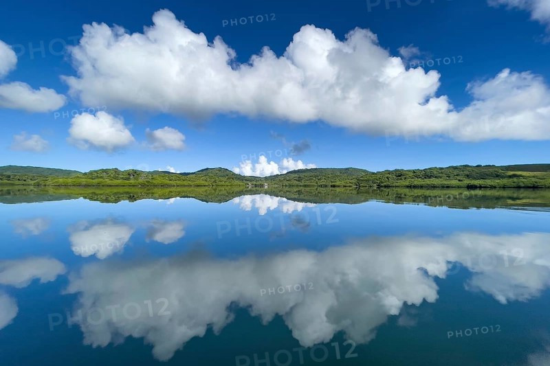 Reflection of clouds Altocumulus in front of blue sky reflected over in Pacific Still ocean without any waves with in mirror smooth sea surface water surface mirror smooth sea