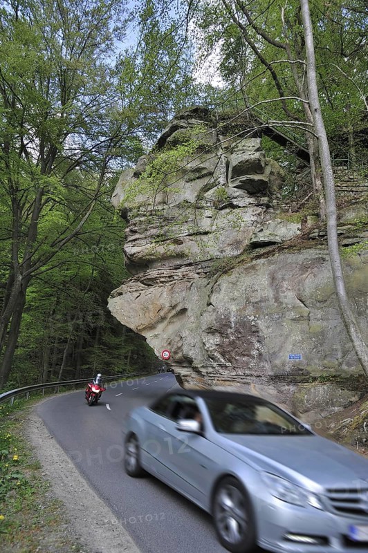 Car driving under the sandstone rock formation Predigtstuhl in Berdorf