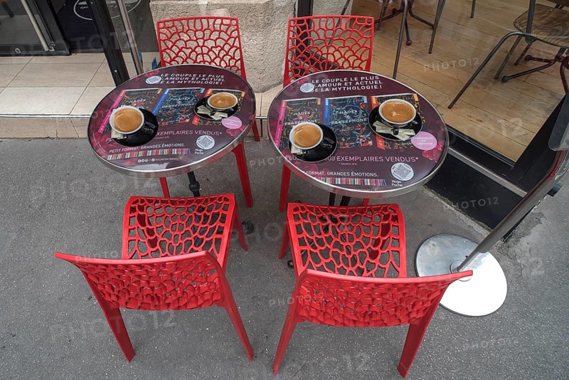 Espressos on bistro tables in front of a cafe