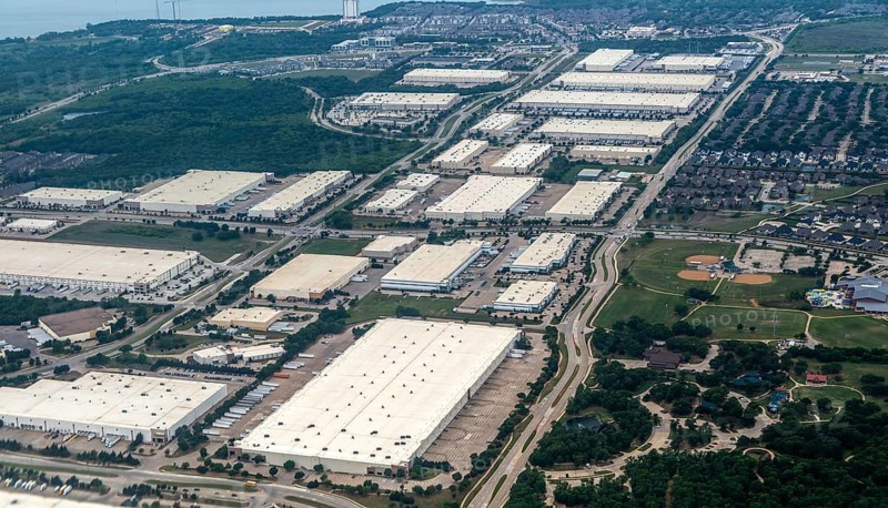 Oblique angle aerial view of large distribution centre logistics warehouse buildings on landing approach to Fort Worth