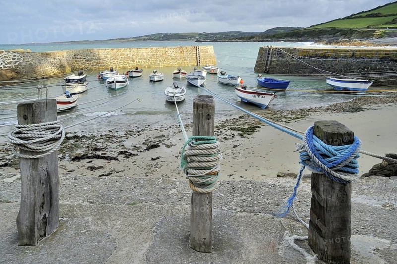 Knots in ropes of moored boats around wooden mooring posts at Port Racine