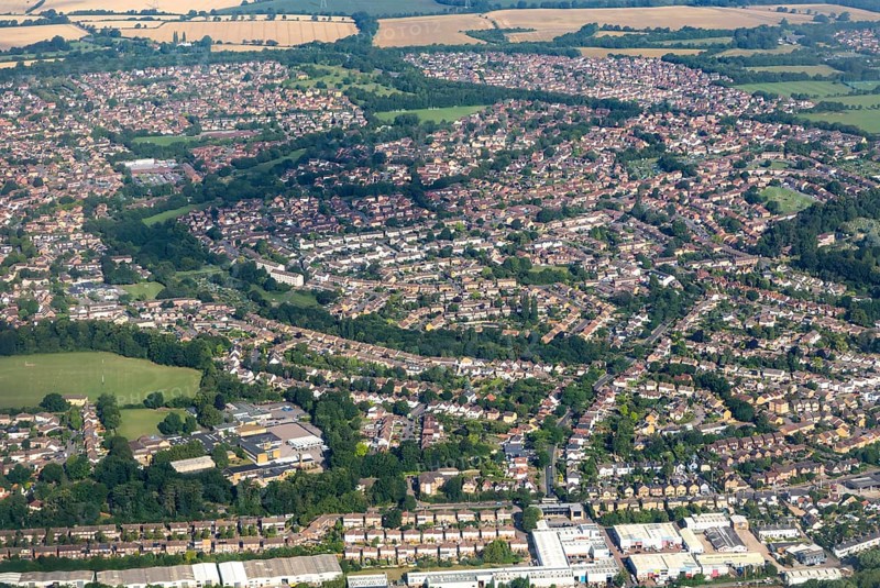 Oblique aerial view through plane window of housing estates in Bishop's Stortford town
