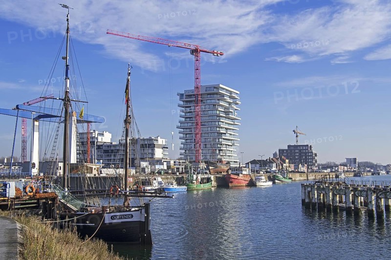 Two-master sailing vessel Nele and new flats being build for real estate project Oosteroever in the Ostend harbour along the Belgian North Sea coast