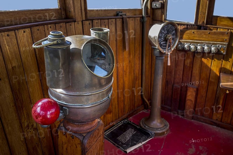 Old brass compass binnacle with iron correcting spheres at each side at bridge of ship