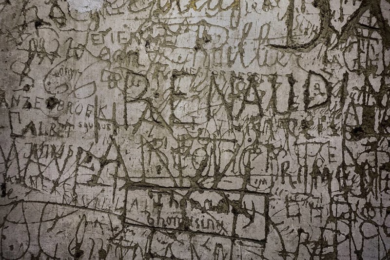Old graffiti and scratchwork on wall inside the medieval Chateau de Bouillon Castle