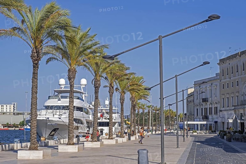 Promenade and motor yachts docked in the seaport