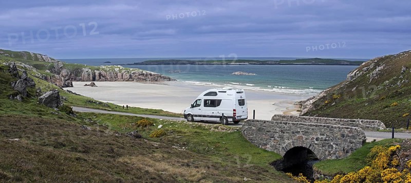 Motorhome driving on desolate road past Ceannabeinne Beach in summer near Durness
