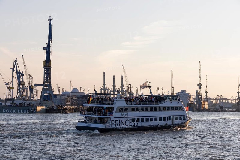 Party guests on the excursion ship MS Princess at dusk underway on the Elbe in Hamburg harbour