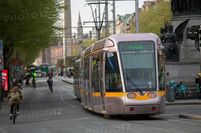 A Luas tram in O'Connell Street with cyclists visible too. Dublin