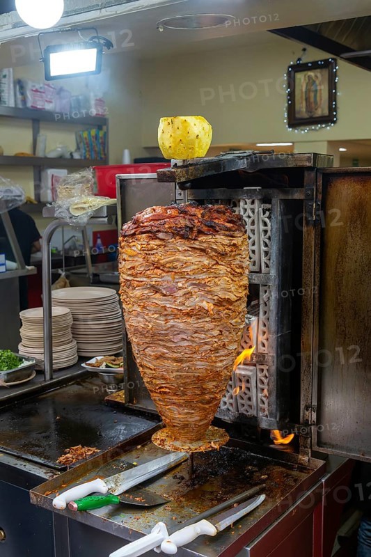 Meat grilling on vertical kebab spit in fast food street restaurant