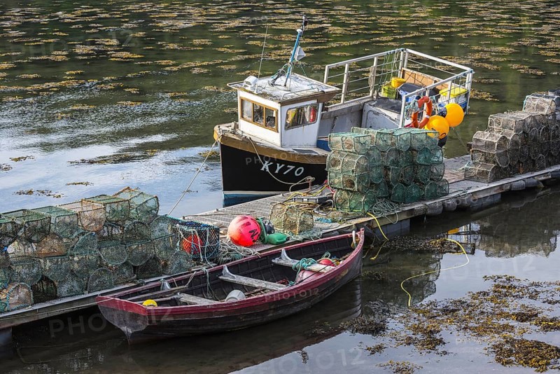 Moored small fishing boat and lobster pots