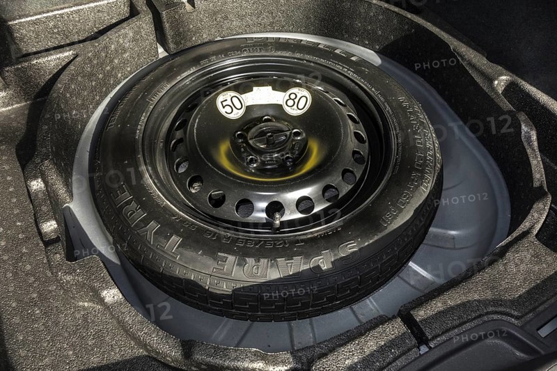 Space-saver spare wheel in trunk of car with limited speed limit of maximum 50 mph 80 km h