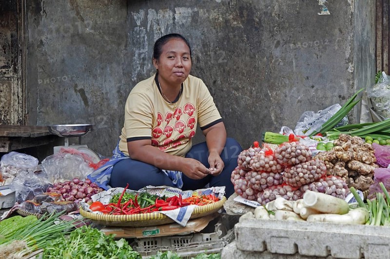 Indonesian vendor selling greens at vegetable market in Jakarta