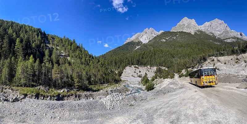 Postbus driving on gravel road in Val S-charl