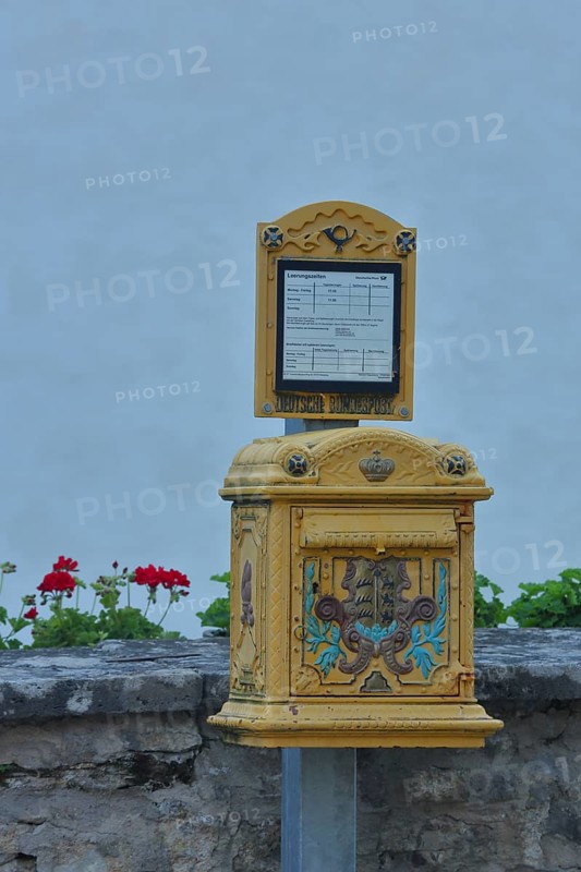 Historical yellow mailbox with ornaments