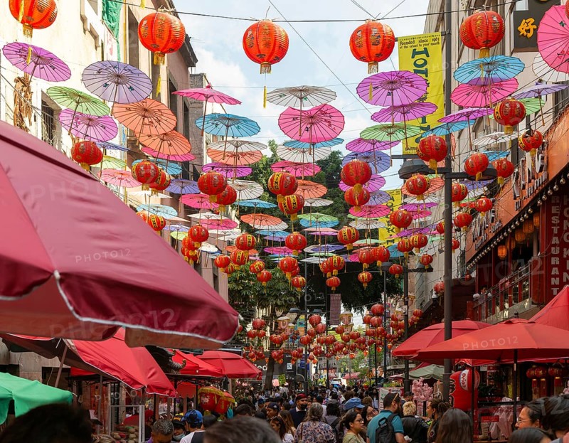 Red paper Chinese lanterns and umbrellas hanging above the street in Chinatown