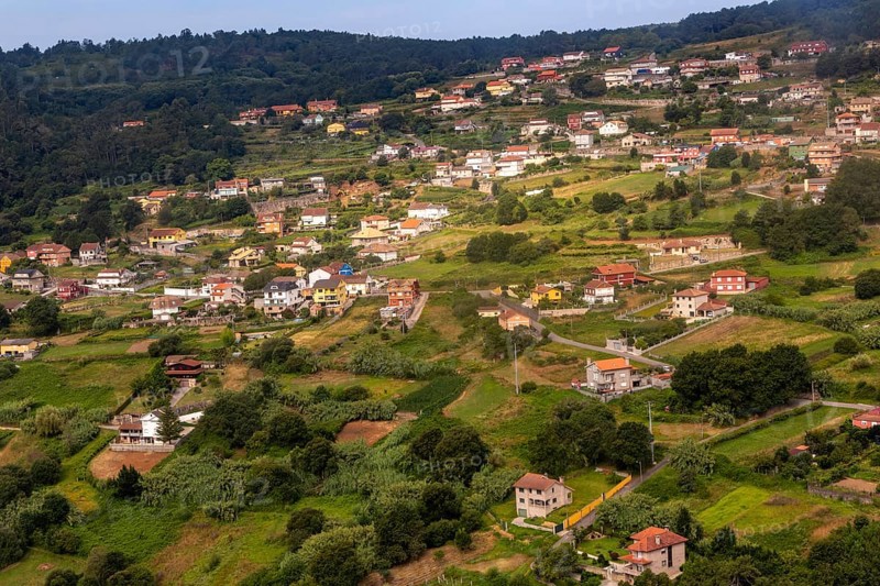 View through plane window of rural landscape and settlement of Negros approaching airport at Vigo