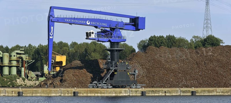 Dock crane and scrap heap along the Ghent-Terneuzen Canal at Ghent seaport