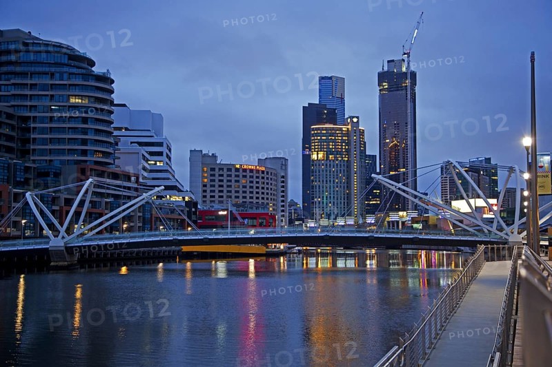 Bridge over the Yarra River and skyline with skyscrapers of the Melbourne City Centre at sunset
