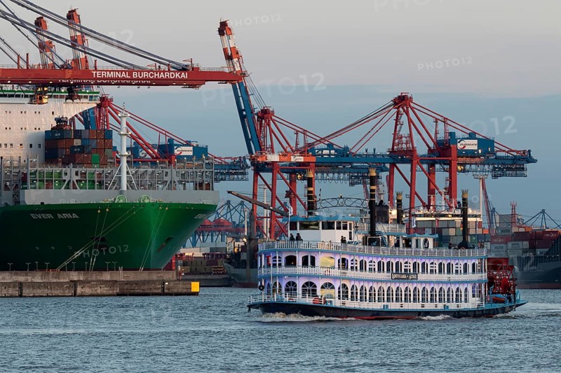 The MS Louisiana Star of the Elbreederei Abicht on a harbour cruise at dusk on the Elbe in front of container ships at the Burchardkai terminal in the Port of Hamburg