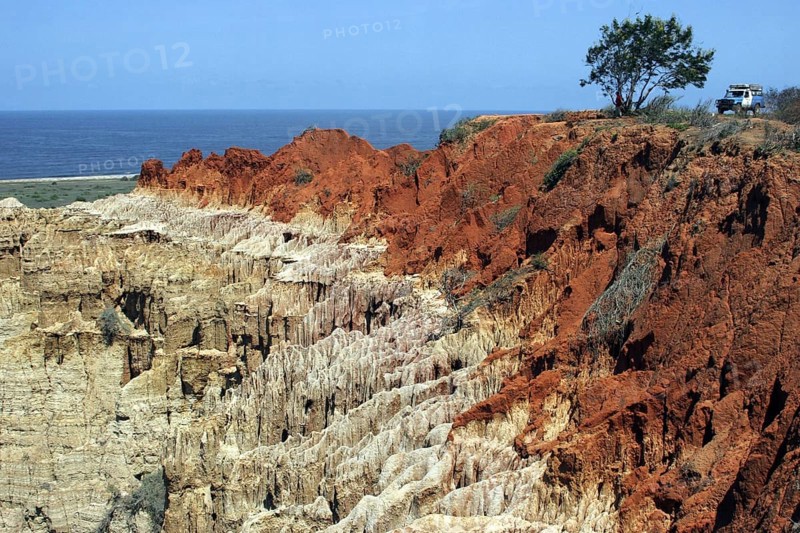 Four-wheel drive vehicle and eroded cliff at the rough coastline between Luanda and Lobito