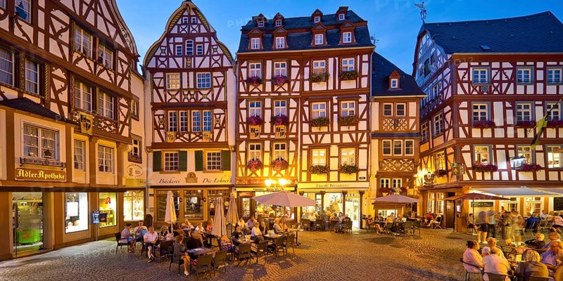 Gabled half-timbered houses on the busy medieval market square in the evening