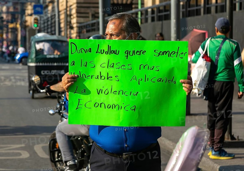 Protestor holding placard blocks traffic on busy city centre road
