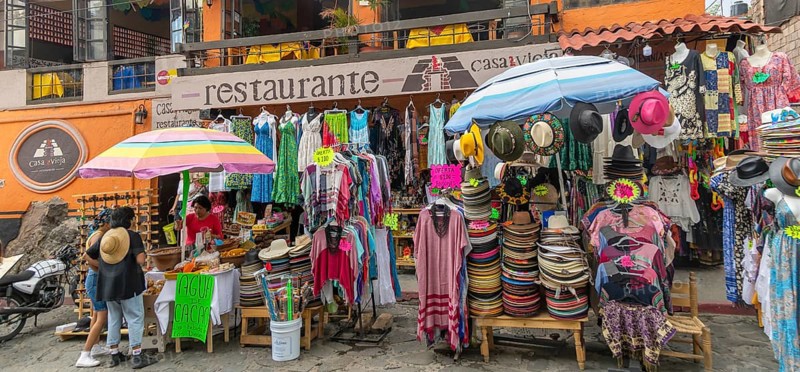 Street market stalls selling hats and clothing