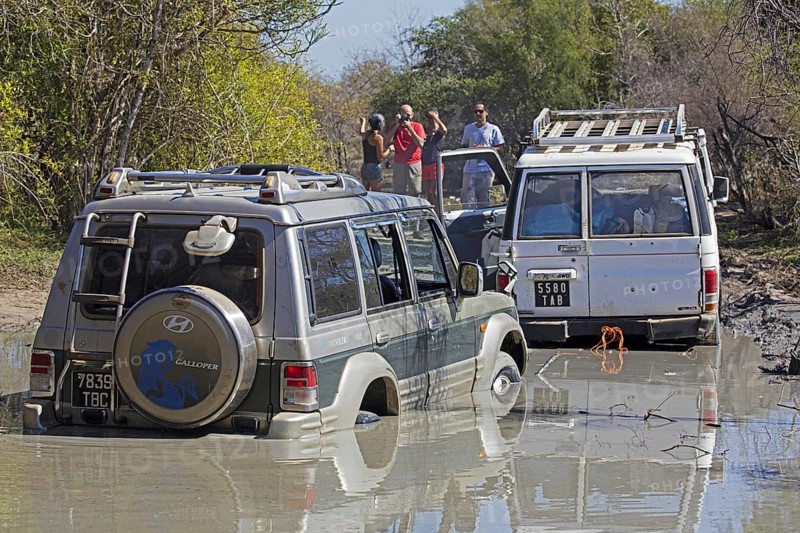 Four-wheel drive vehicle pulling off-road car out of mud on the dirt road from Morondava to Toliara