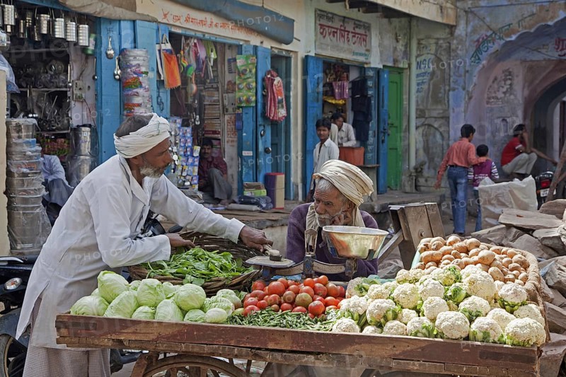 Vendors selling vegetables on wooden cart at market in Barsana