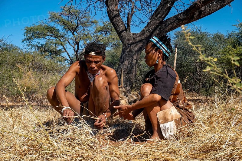 Bushman and San woman making fire in Kalahari