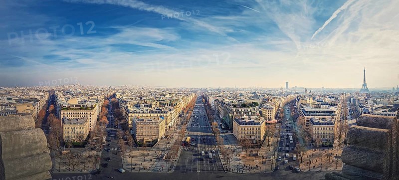 Wide angle Paris cityscape panorama from the triumphal arch with view to parisian avenues and Champs-Elysee in the center. Beautiful architectural landmarks on the horizon